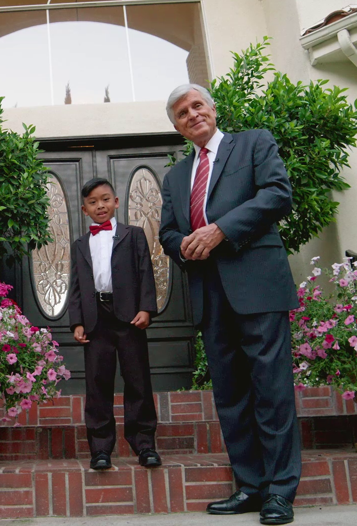 A man and a boy standing together outside a building